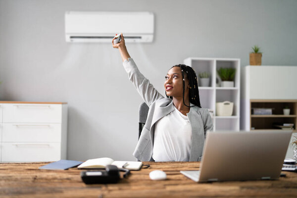 Счастливая молодая предпринимательница работает в офисе с кондиционером