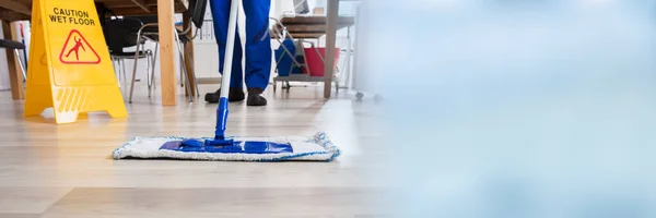 Janitor Rengøring Gulv Foran Gul Forsigtig Wet Floor Sign - Stock-foto