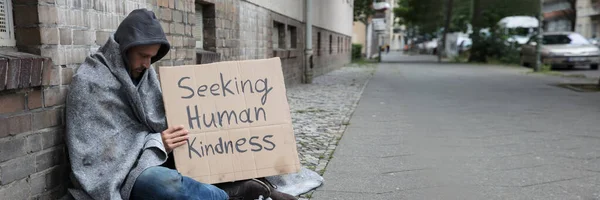 Male Beggar Hood Showing Seeking Human Kindness Sign Cardboard —  Fotos de Stock