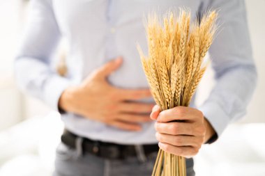 Celiac Disease And Gluten Intolerance. Women Holding Spikelet Of Wheat clipart
