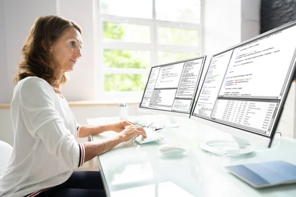 多台计算机屏幕上的程序员妇女编码 — 图库照片