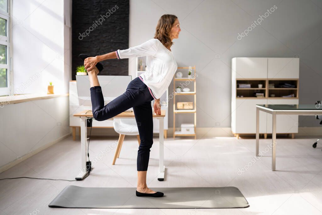 Happy Young Businesswoman Doing Stretching Exercise At Workplace