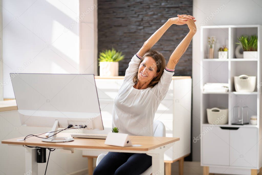 Woman Stretches At Office Desk. Stretch Exercise On Chair