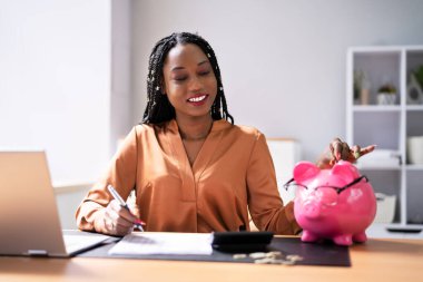 Piggybank masasında para koyarak faturaları ile mutlu kadın