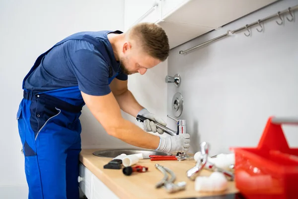 Jovem Feliz Masculino Encanador Fixando Torneira Cozinha — Fotografia de Stock