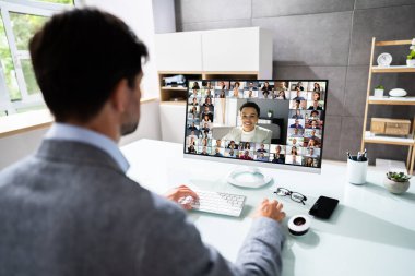 Onun ortaklar bilgisayardaki ile genç işadamı video konferans