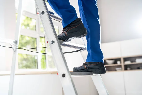 Low Section View Of A Handyman\'s Foot Climbing Ladder
