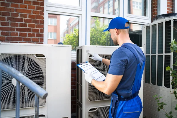 Dwóch Elektryków Mężczyźni Kurtkach Bezpieczeństwa Sprawdzanie Jednostki Klimatyzacji Dachu Budynku — Zdjęcie stockowe