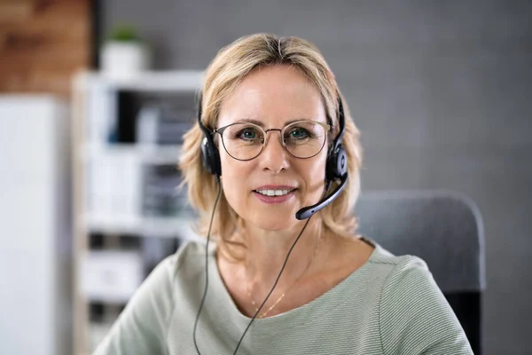 Business Service Agent With Headset At Computer On Phone