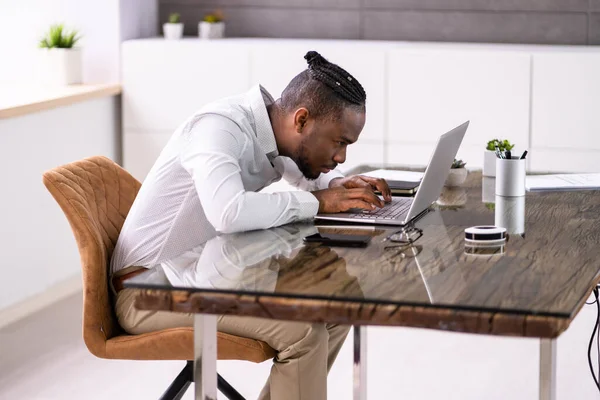 African Man Bad Posture Working Typing At Desk