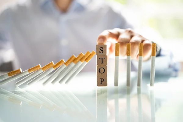 Man Stopping Cigarette Falling Desk Wooden Blocks — Zdjęcie stockowe