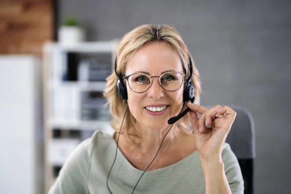 Business Service Agent With Headset At Computer On Phone