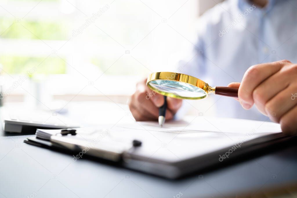 Auditor Doing Tax Fraud Investigation Using Magnifying Glass
