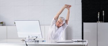 Happy Office Worker Stretching And Relaxed Behind PC
