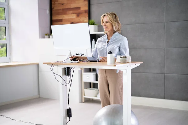 Ofisteki Ayarlanabilir Yükseklik Masasını Duruş Çin Kullanan Kadın — Stok fotoğraf