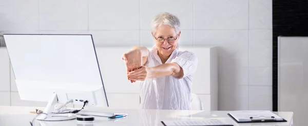 Happy Office Worker Stretching And Relaxed Behind PC