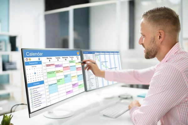 Employee Working On Calendar Schedule And Staff Time Sheet