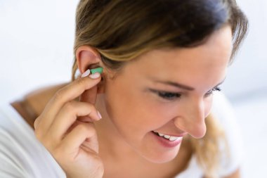 Woman Using Ears Stoppers In Home Bedroom