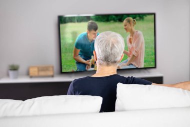 Watching TV Or Television In Living Room At Sofa