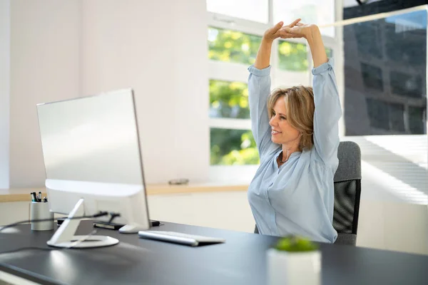 在办公室电脑上工作时伸展手臂运动 — 图库照片