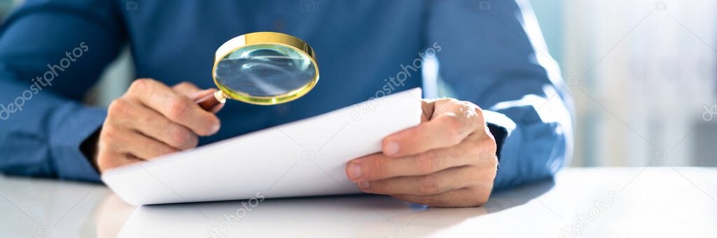 Audit Accountant Using Magnifier Glass. Paper Document Audit