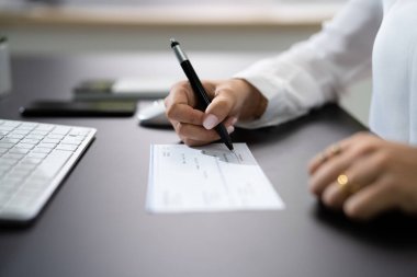Woman Signing Bank Payroll Check Or Paycheck clipart