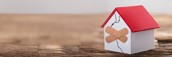 Сломанный дом с лейкопластырем. Ремонт дома