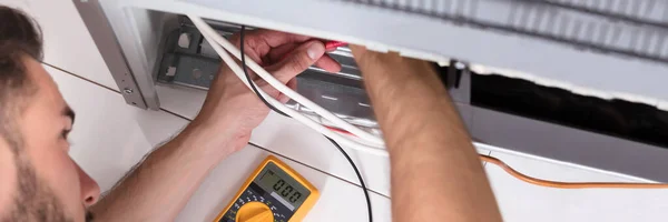 Fridge Appliance Repair At Home. Man Fixing Refrigerator