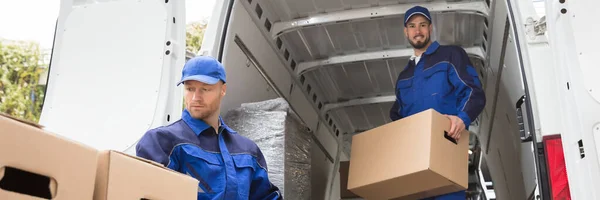Van Movers Unloading Cardboard Boxes From Delivery Truck
