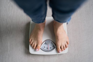 Kadın Ayakları Banyo 'da Kilo Ölçeğinde Duruyor. Kolesterol Kontrolü