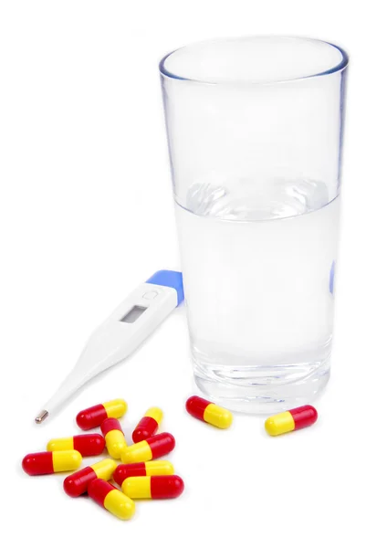 Pills and glass of water and thermometer — Stock Photo, Image