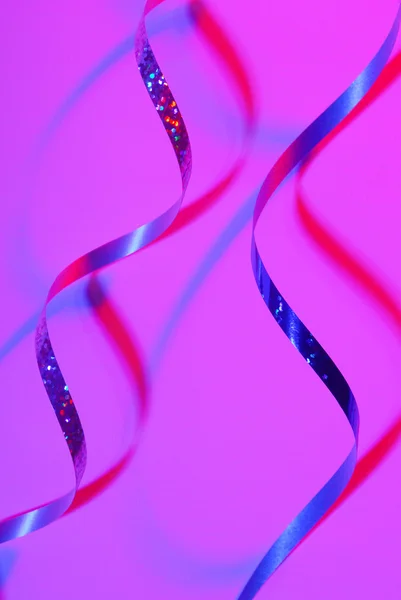 Лента Confetti serpentine на цветном фоне — стоковое фото
