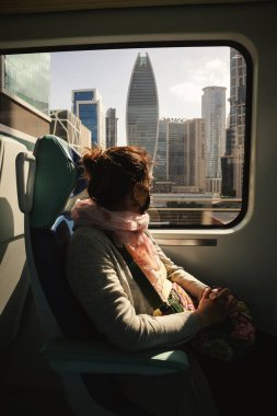 Dubai, Birleşik Arap Emirlikleri - 21 Ocak 2022: Dubai metrosunda kadınlar şehri geziyor ve izliyorlar.