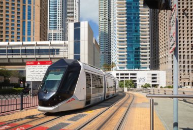 Dubai, Birleşik Arap Emirlikleri - 21 Ocak 2022: Arka planda Dubai Marina binaları, yeni ve modern bir tramvayda görüntüleme. 