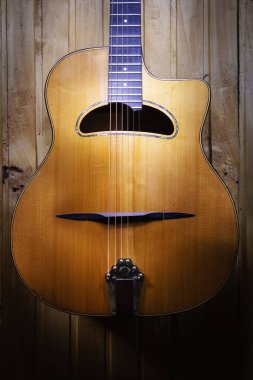 Güzel çingene caz akustik gitar detayları, ahşap duvarda asılı..