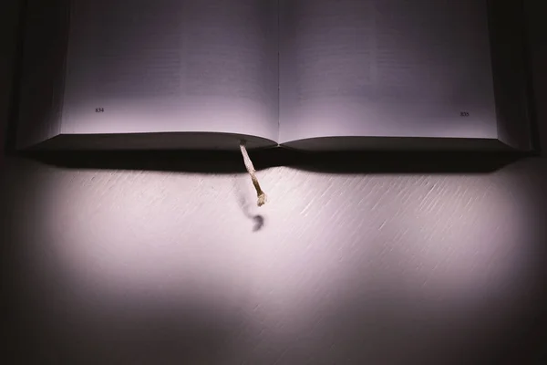 Ένα Ανοιχτό Χοντρό Βιβλίο Στο Λευκό Τραπέζι Στο Σκοτάδι — Φωτογραφία Αρχείου