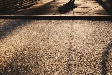 Parkta salıncakta sallanan küçük bir çocuğun gölgesi..