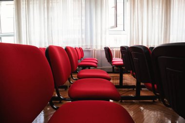 Kırmızı sandalyeli bir sınıfın içinde.. 