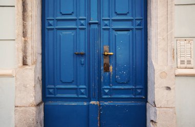Closeup view of an entrance of a building, old wooden blue door details. 