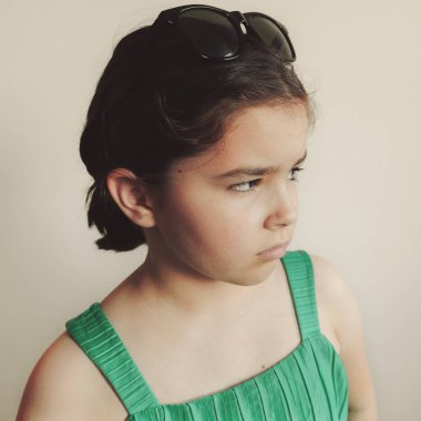 Küçük kız poz veriyor, yüz ifadesi.