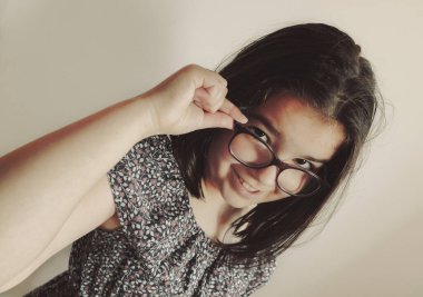 Küçük kız poz veriyor, yüz ifadesi.