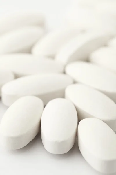 Comprimidos médicos brancos sobre branco — Fotografia de Stock