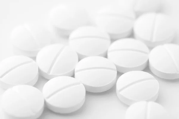 Белые таблетки на белом фоне — стоковое фото