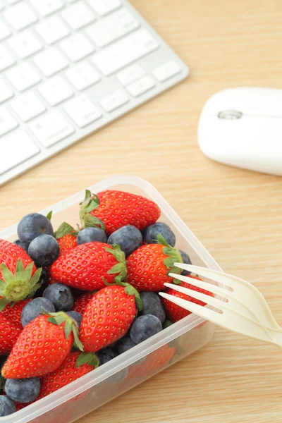Boîte à lunch saine avec mélange de fraises et de bleuets au bureau — Photo