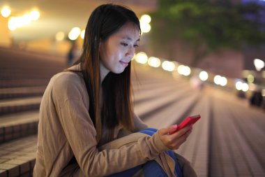 gece şehirde telefon kullanan kadın