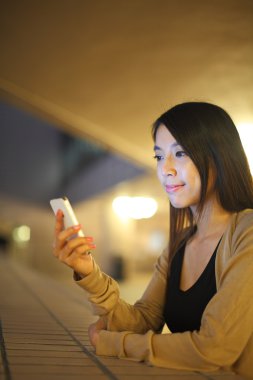 gece şehirde telefon kullanan kadın