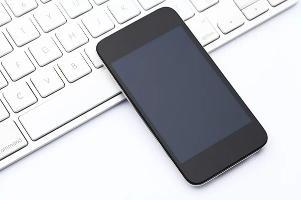 Smartphone on computer keyboard — Stock Photo, Image