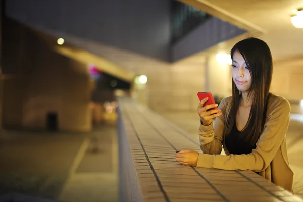Donna che utilizza il telefono cellulare in città di notte — Foto Stock