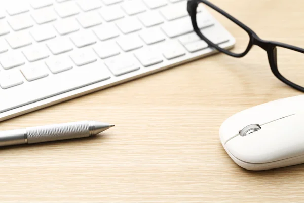 Teclado, pluma, ratón y gafas en el escritorio — Foto de Stock