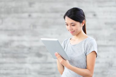 Tablet bilgisayar kullanan genç Asyalı kadın.